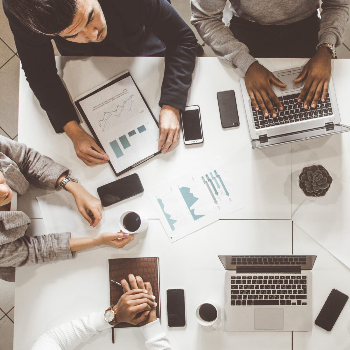 top view work workplace. A team of young office workers, businessmen with laptop working at the table, communicating together in an office. Corporate businessteam and manager in a meeting. coworking.
